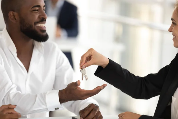 Realtor giving keys to new apartment to african american husband — Stock Photo, Image