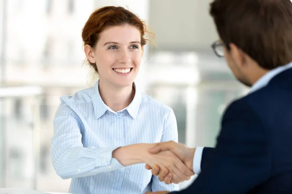 Close-up glimlachen aantrekkelijke vrouw handdrukken met baas bij vergadering. — Stockfoto