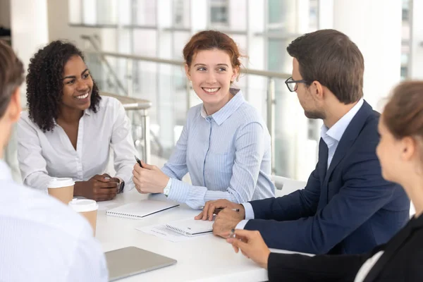 Jeune femme souriante heureuse parlant à un collègue au bureau . — Photo