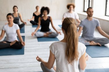Dikiz aynası kadın koçu ve yoga sırasında meditasyon yapan insanlar.