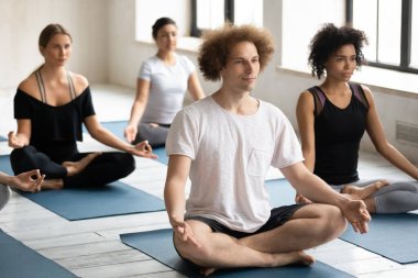 Kafkas erkek yogi koçu ve çok ırklı insanlar seans sırasında meditasyon yapıyorlar.