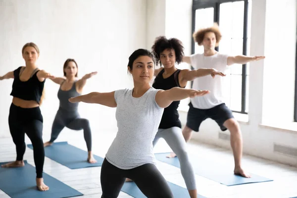 Indiase coach training groep van mensen die Warrior twee positie — Stockfoto