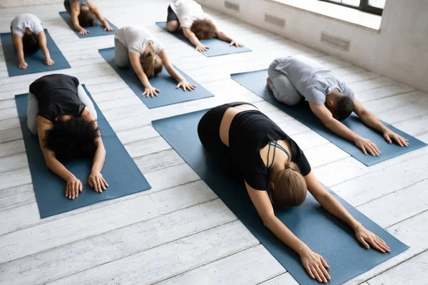 Durante el ejercicio grupal de yoga diversas personas haciendo Child Pose asana —  Fotos de Stock