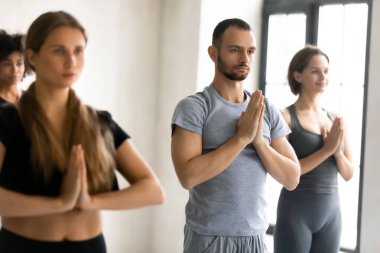 İnsanlar içeride elleri bağlı durarak Namaste jesti yapıyorlar.