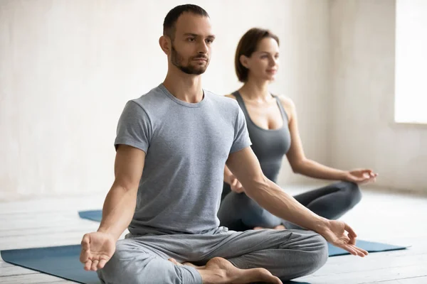 People meditating sitting on mats, focus on male instructor — Stock Photo, Image
