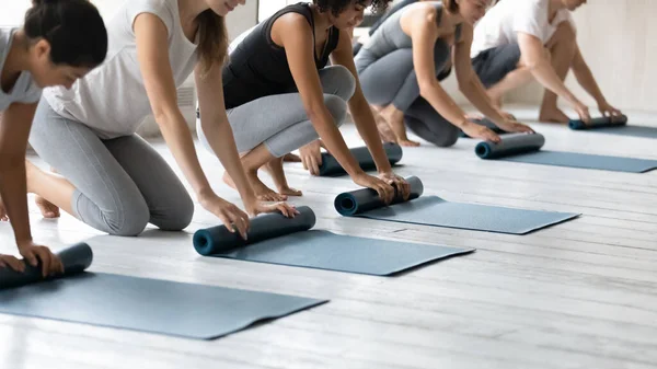Le persone multietniche tappeti pieghevoli finito sessione di yoga al club sportivo — Foto Stock