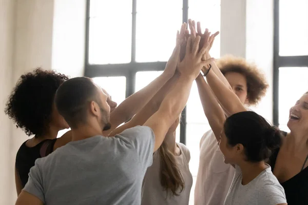 Multiethnic sportive people stacked palms together celebrating sport victory — Stock Photo, Image