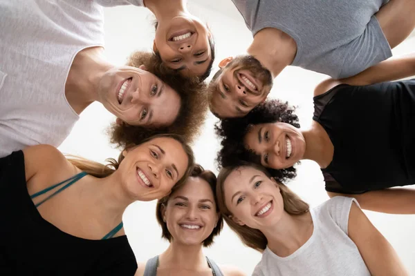 Multiethnic people standing in circle leaned to look at camera — Stock Photo, Image