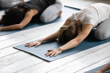Women practicing Child Pose reducing fatigue after workout close up