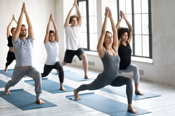 Giovani che praticano yoga facendo guerriero un esercizio — Foto Stock