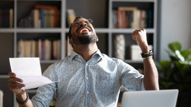Overjoyed young mixed race man celebrating unbelievable triumph.