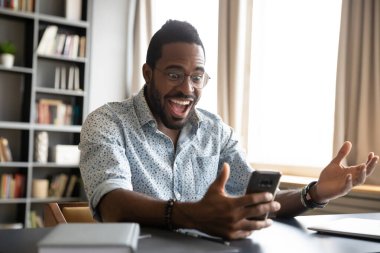 Overjoyed successful young african american businessman read message.