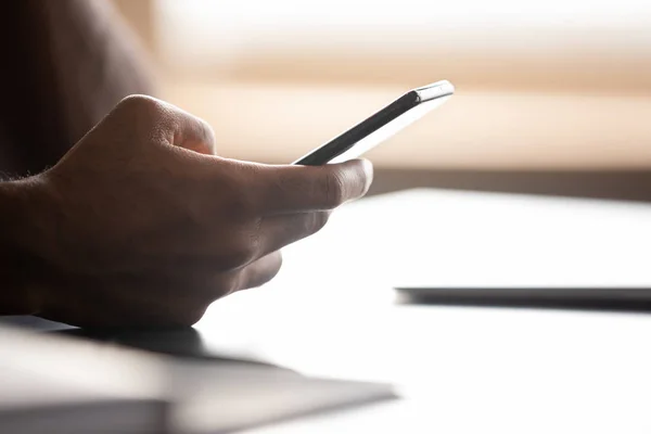 Close up focus on smartphone in african american male hands. — Stock fotografie