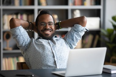 Smiling young african american businessman relaxing on chair.