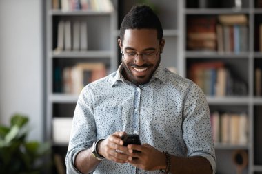 Happy african ethnicity guy web surfing information or shopping.