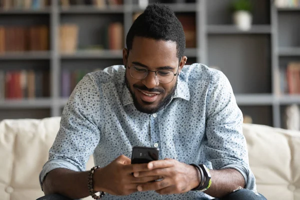 Happy biracial guy playing online game on mobile phone. — Stock Photo, Image