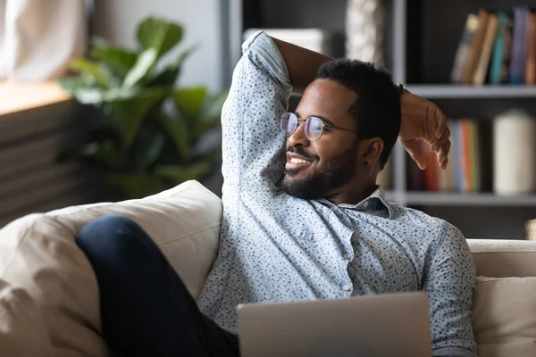 Smiling peaceful handsome african american guy visualizing future at home.