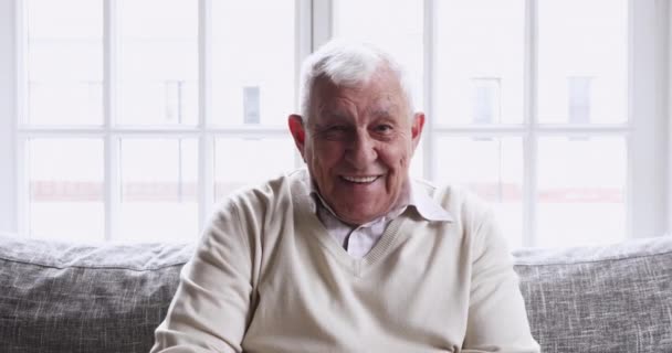 Feliz avô sênior falando olhando para a câmera em casa — Vídeo de Stock