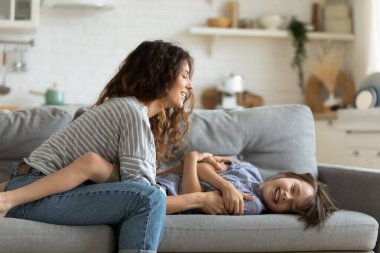Neşeli genç anne ve küçük oğlu evde oynuyorlar.