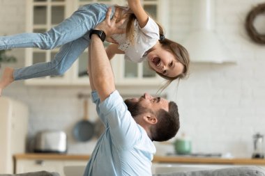 Çok mutlu bir baba evde küçük kızıyla oynuyor.