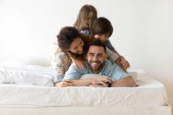 Glückliche junge Familie mit Kindern entspannen im Schlafzimmer — Stockfoto