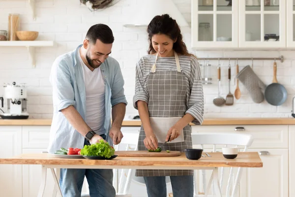 Modern mutfakta birlikte yemek yapan genç ve mutlu bir çift. — Stok fotoğraf