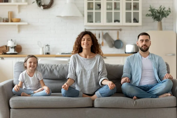 Junge Familie mit kleiner Tochter übt gemeinsam Yoga — Stockfoto