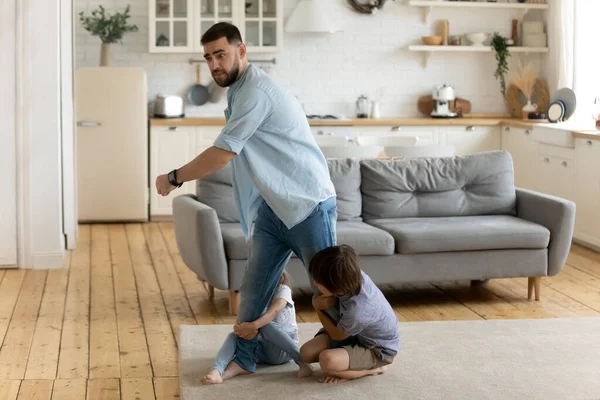 Zwei kleine Kinder lassen Vater nicht gehen — Stockfoto