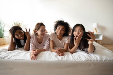 Güzel Asyalı kadın arkadaşlarıyla pijama partisinde selfie çekiyor.
