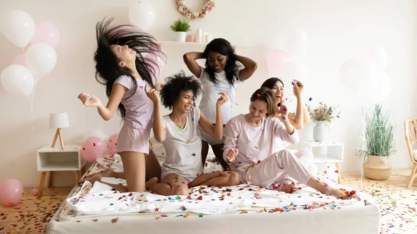 Happy diverse girls having fun, celebrating in bedroom with confetti — Stockfoto