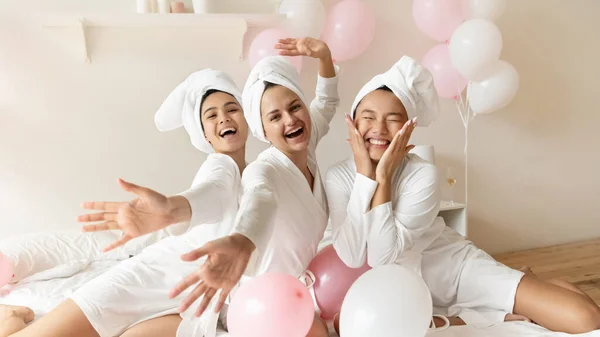 Portrait funny Asian bride with bridesmaids sitting on bed — Stockfoto