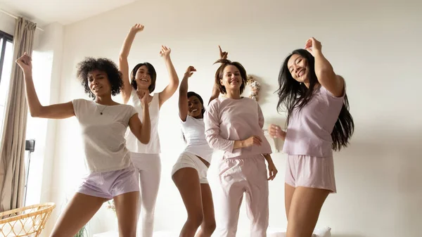 Портрет красивые разнообразные девушки танцуют на кровати вместе — стоковое фото