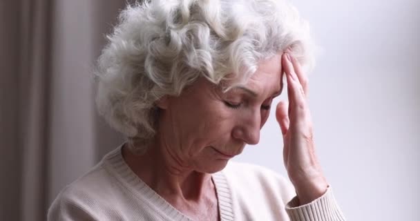 Больная женщина в возрасте гипертонии страдающая головной болью концепция — стоковое видео