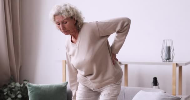 Cansada mulher idosa sente dor súbita nas costas em casa — Vídeo de Stock