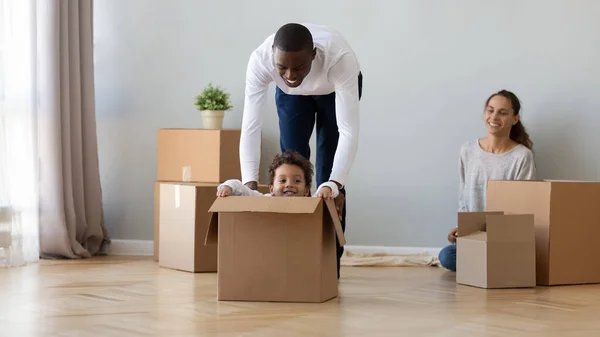 Счастливая афроамериканская семья переезжает, веселится в новой квартире — стоковое фото
