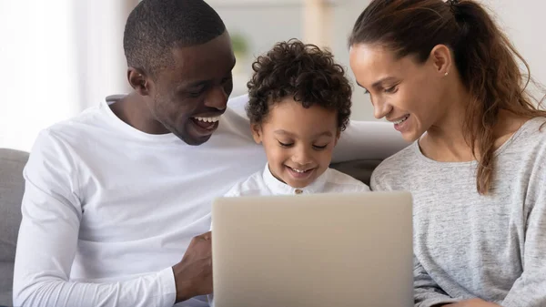 Feliz familia afroamericana con su pequeño hijo usando el ordenador portátil juntos — Foto de Stock