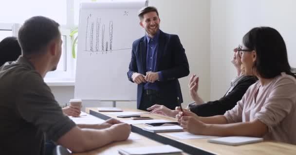 Orador masculino confiante sorrindo apresentando plano de marketing para colegas de trabalho . — Vídeo de Stock