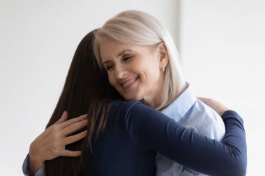 Gülümseyen olgun anne ve kız çocuğu barışıyorlar.