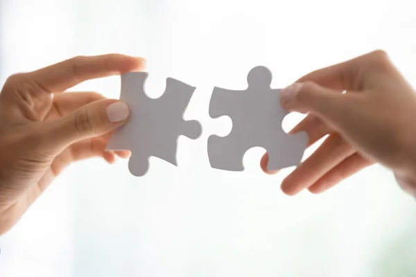 People assembling jigsaw puzzle engaged in teambuilding — Stock Photo, Image