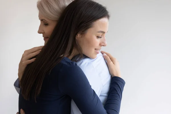 Sorrindo mãe sênior e adulto filha abraçando — Fotografia de Stock