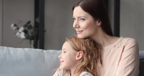 Madre soltera cariñosa abrazando hija niña mirando hacia otro lado soñando — Vídeos de Stock