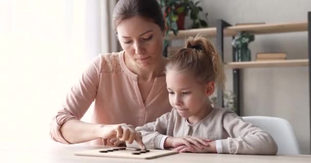 Chica de la escuela inteligente jugando draughts juego de mesa con la madre — Vídeo de stock