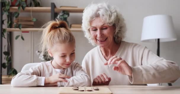 Feliz familia de dos generaciones de edad jugando juego de damas en la mesa — Vídeo de stock