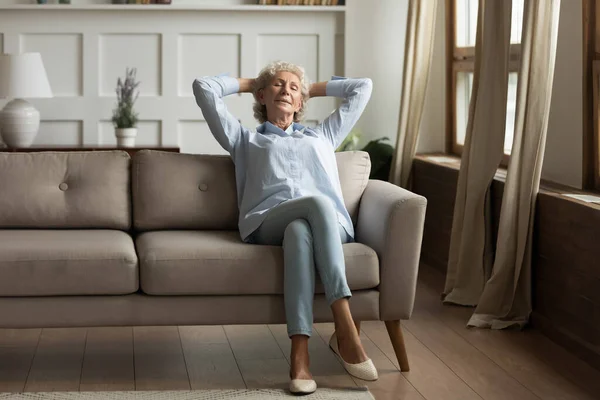 Madura mujer relajarse en sofá tomando siesta en casa — Foto de Stock