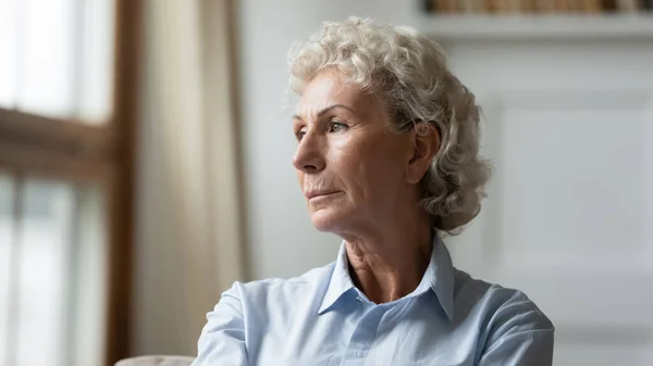 Mulher idosa pensativa perdida em pensamentos sentindo-se sozinha — Fotografia de Stock