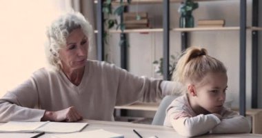 Worried senior grandma scolding lazy grandchild demanding homework