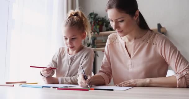 Счастливая мама помогает дочери рисовать цветные карандаши дома — стоковое видео