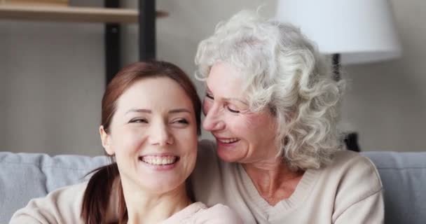 Cheerful two age generations women bonding on sofa, closeup portrait — ストック動画