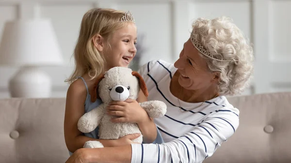 Happy mature grandmother and little granddaughter play together — Stock Photo, Image