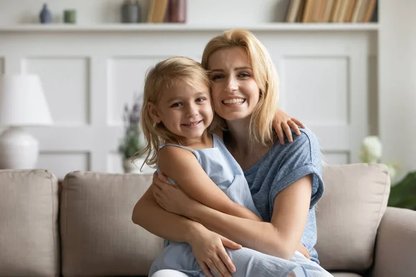 Lächelnde Mutter und kleine Tochter entspannen zu Hause — Stockfoto